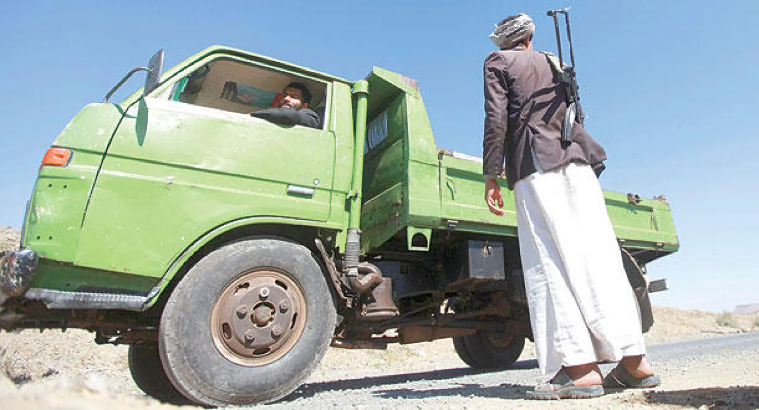 أحد أفراد ميليشيا الحوثي في إحدى نقاط التفتيش جنوب العاصمة صنعاء أمس (رويترز)