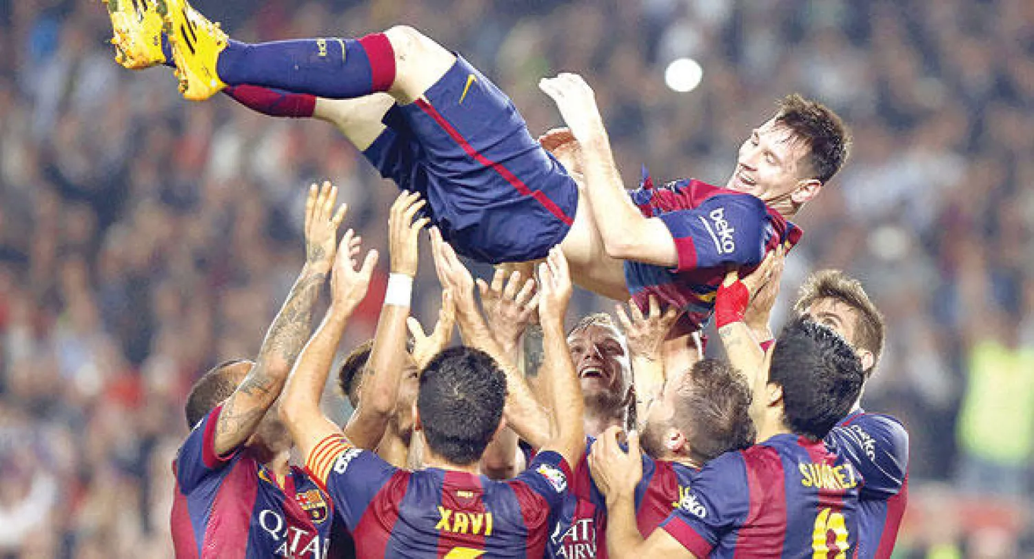 لاعبو برشلونة يحتفلون بميسي بعد إنجازه التاريخي (إ.ب.أ)