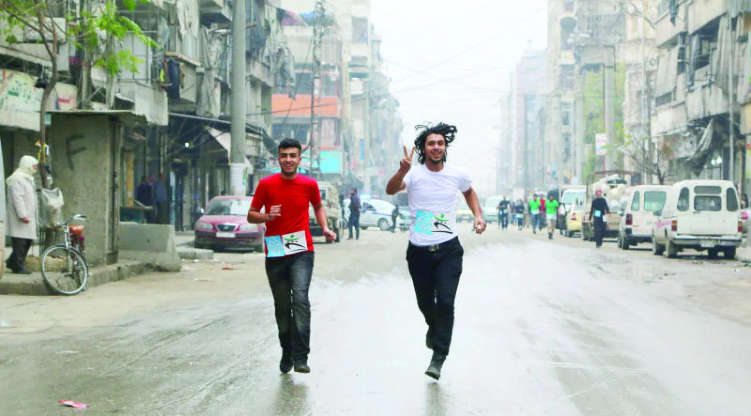 مشاركان في مسابقة جري قبل يومين من الاحتفال بذكرى شهداء النهر في حي «بستان القصر» الواقع تحت سيطرة المعارضة بمدينة حلب (رويترز)