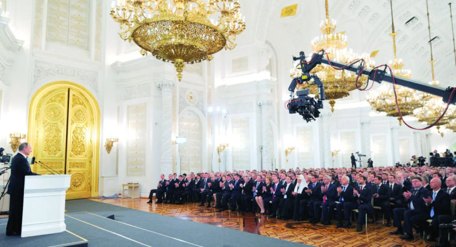 بوتين أثناء إلقاء خطابه إلى الأمة بحضور أعضاء مجلسي البرلمان في موسكو أمس (أ.ب)