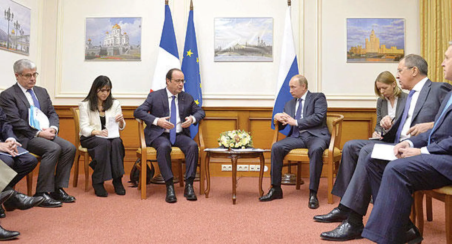 بوتين (وسط يمين) أثناء اجتماعه مع هولاند (وسط يسار) في مطار فنوكوفو بموسكو أمس (إ.ب.أ)