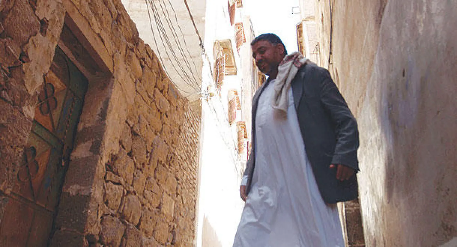 يمني يسير أمام المبنى الذي جرت فيه محاولة تحرير الرهينة الاميركي دانيال سومرز في صنعاء القديمة أمس (أ.ف.ب)