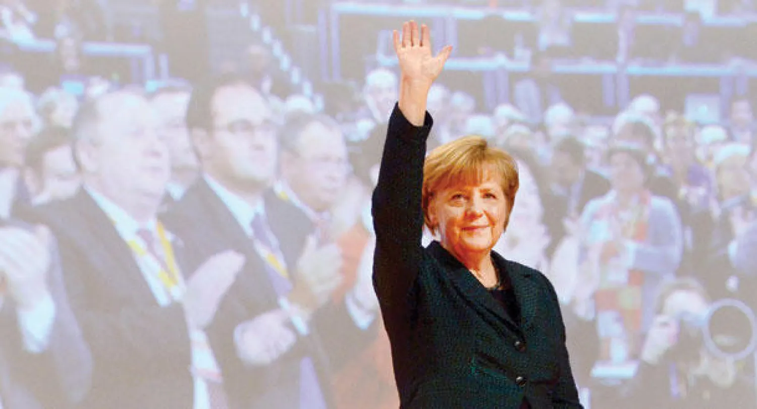 المستشارة الألمانية أنجيلا ميركل تحيي الجمهور بعد خطابها في مؤتمر حزبها، أمس، في مدينة كولونيا غرب ألمانيا (أ.ف.ب)