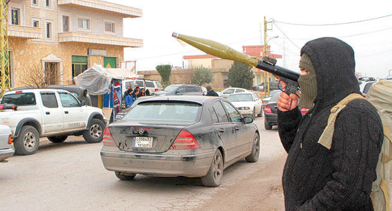 رجل مسلح أمام قرية البزالية التي ينتمي لها العسكري اللبناني الذي أعدمته جبهة النصرة قبل أيام مما تسبب في تجميد الوساطة مع الخاطفين (رويترز)