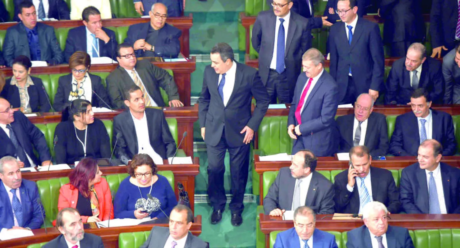 رئيس الوزراء التونسي مهدي جمعة (وسط) لدى وصوله الى مقر البرلمان لمناقشة أولية للميزانية العامة للدولة لعام 2015 (أ.ف.ب)