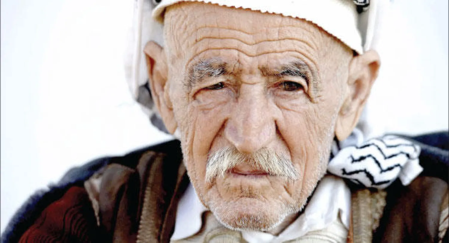 مسن إيزيدي في مخيم بحركة بالقرب من أربيل أمس حيث يقيم 3600 نازح عراقي فروا من «داعش» ويعانون من شدة البرد مع قدوم فصل الشتاء (إ.ب.أ)