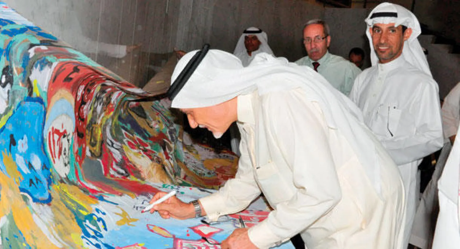 الأمير تركي الفيصل يوقع على أحد الأعمال الفنية لعبد العظيم الضامن