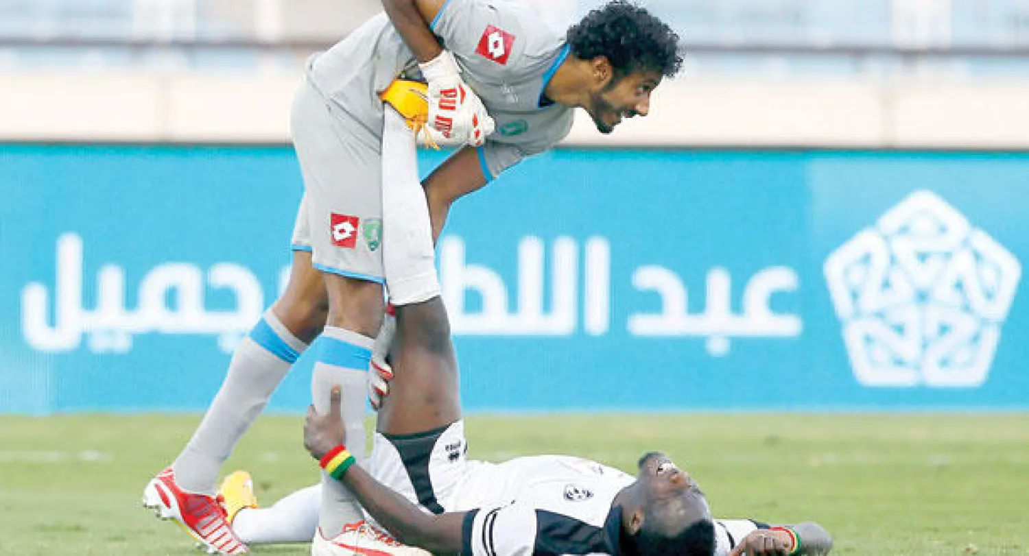 العويشير حارس الفتح في لقطة تجسد الروح الرياضية يحاول من خلالها مساعدة سوماه لاعب هجر الذي تعرض لشد عضلي (تصوير: عيسى الدبيسي)