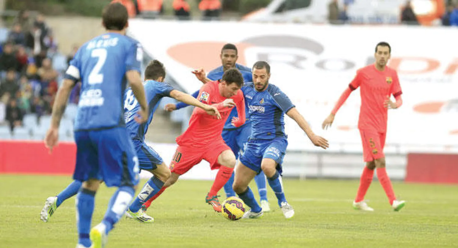 مدافعو خيتافي يمنعون  ميسي من العبور في محاولات تكررت كثيرا (إ.ب.أ)