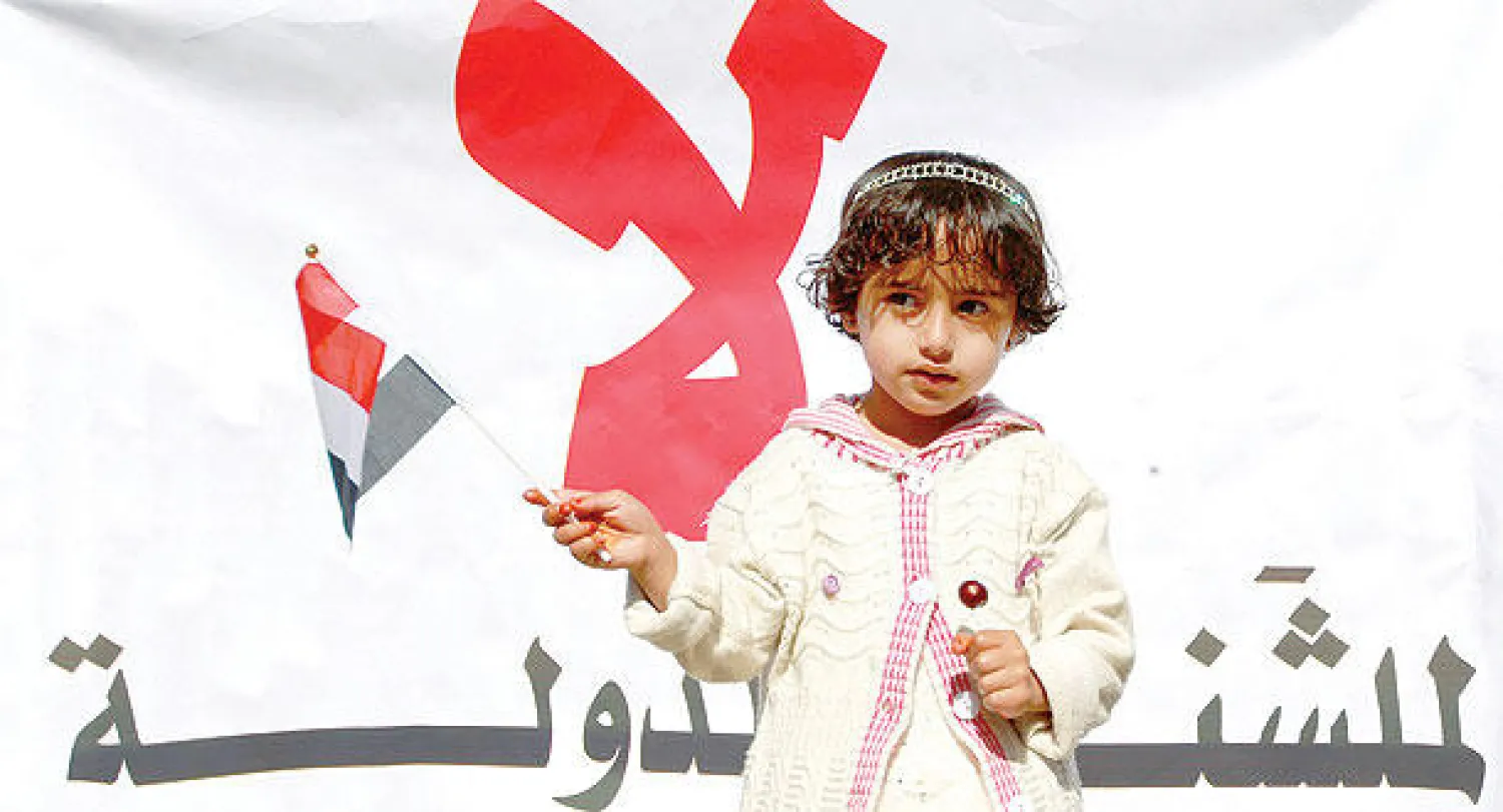 طفلة ترفع العلم اليمني خلال مظاهرة ضد هيمنة عناصر «أنصار الله» الحوثية على مقاليد الدولة، في العاصمة صنعاء أمس (أ.ف.ب)