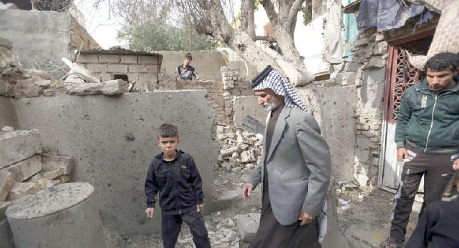 عراقيون يعاينون آثار قذائف هاون سقطت في كربلاء مساء أول من أمس (أ.ب)