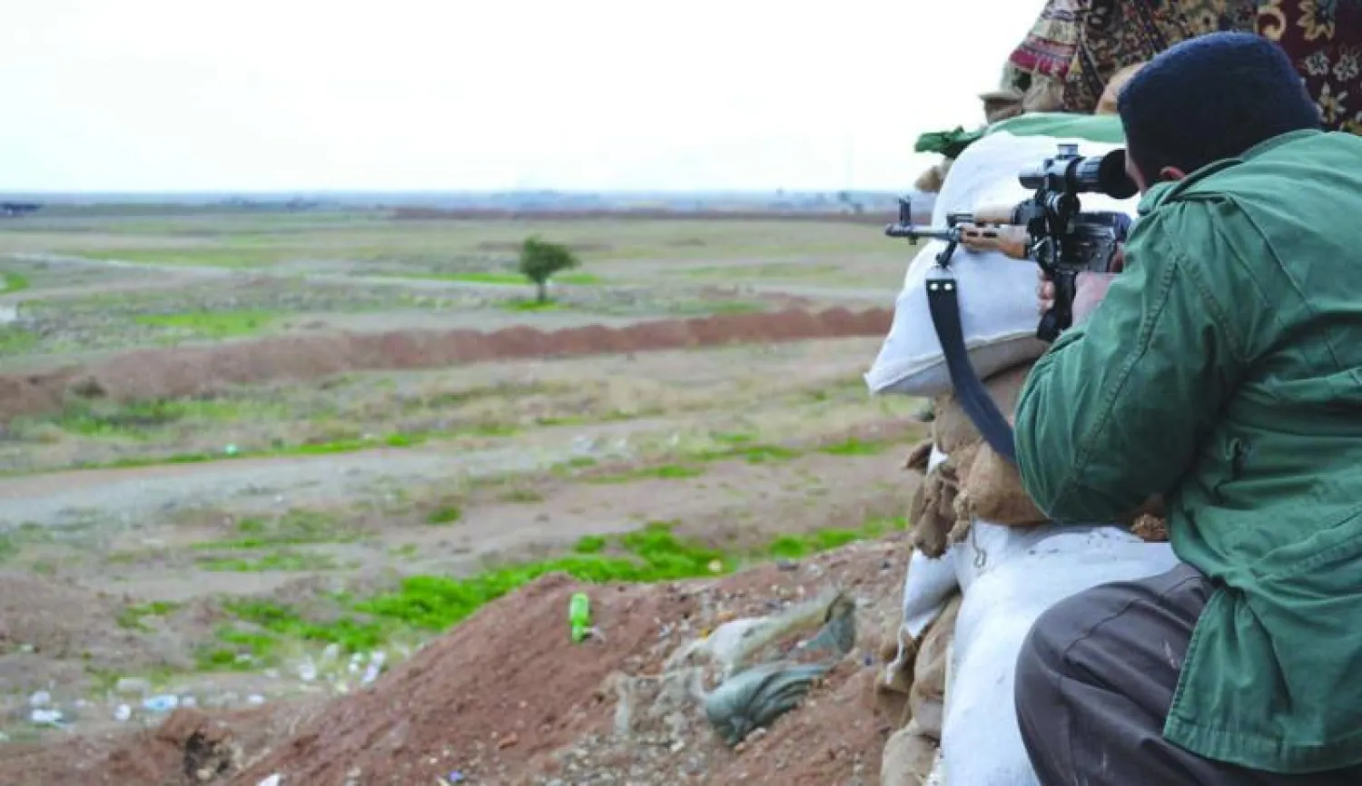 عنصر في البيشمركة يراقب منطقة تفصل بين القوات الكردية ومواقع «داعش» في تل الورد غرب كركوك أمس (أ.ف.ب)