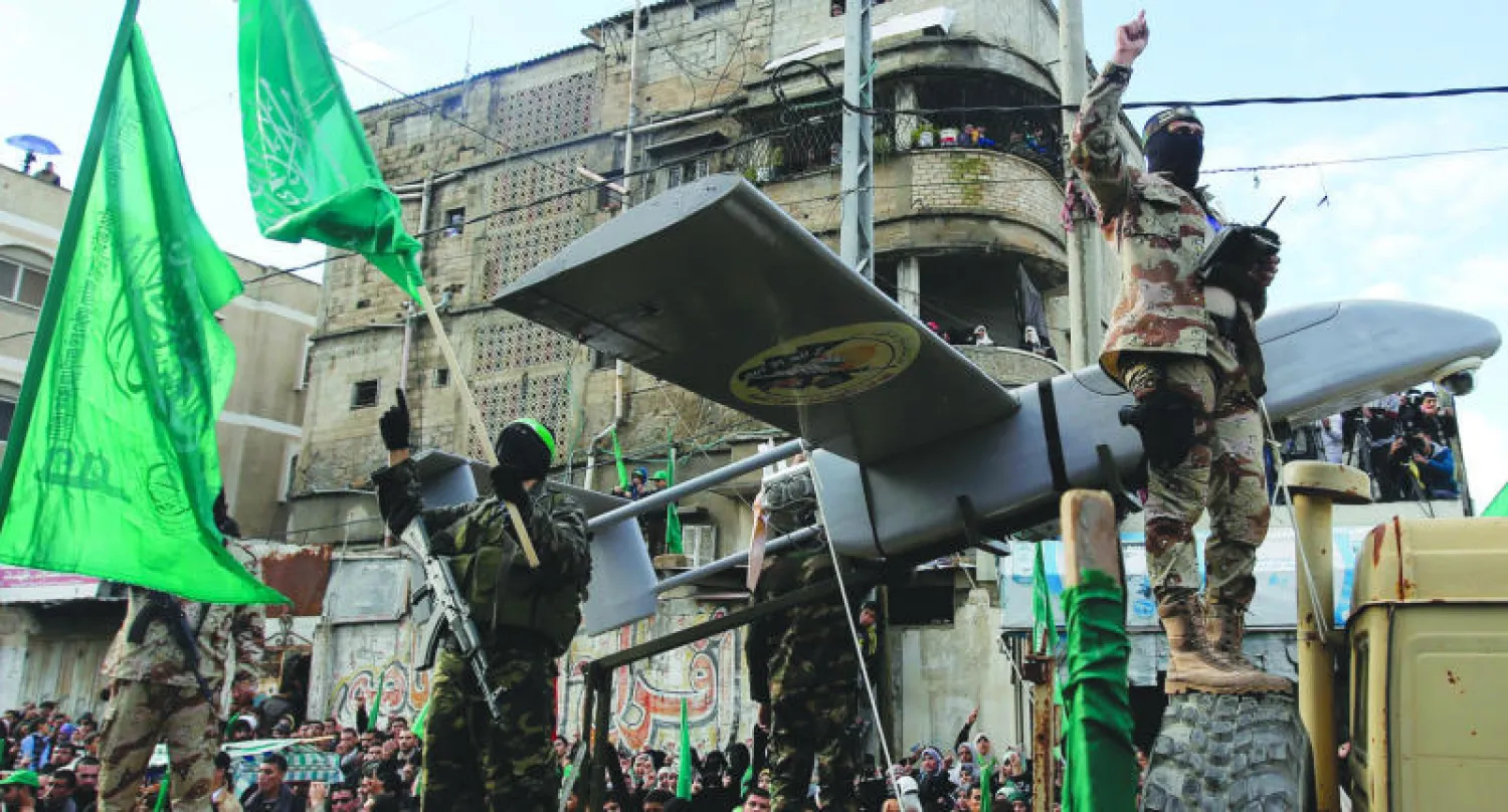 مقاتلون من كتائب عز الدين القسام التابعة لحماس يستعرضون طائرة من دون طيار (إ.ب.أ)
إسماعيل هنية القيادي في حماس يحيي المحتفلين وقد ظهر إلى جانبه آخرون من قيادة حماس (إ.ب.أ)