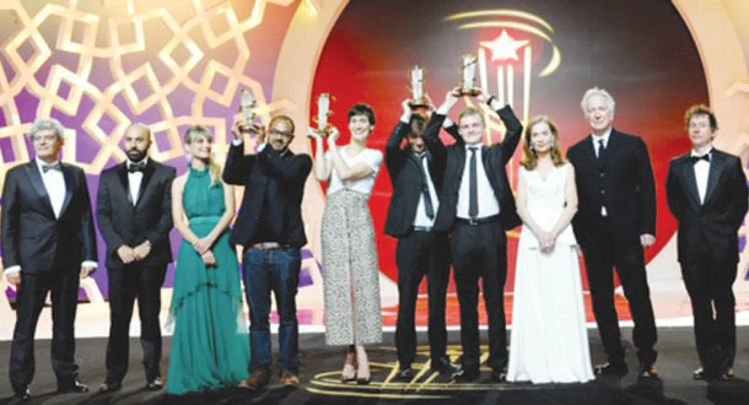 الفائزون بجوائز «لجنة التحكيم» و«أحسن إخراج» و«أفضل ممثلة» و«أفضل ممثل» مع أعضاء لجنة تحكيم مسابقة الدورة الـ14 للمهرجان الدولي للفيلم بمراكش («الشرق الأوسط»)