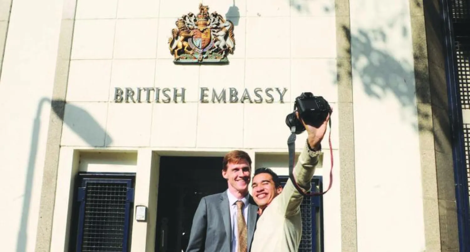 السفير البريطاني لدى مصر جون كاسن في صورة «سيلفي» مع أحد المواطنين المصريين أمام مدخل السفارة أمس (أ.ب)