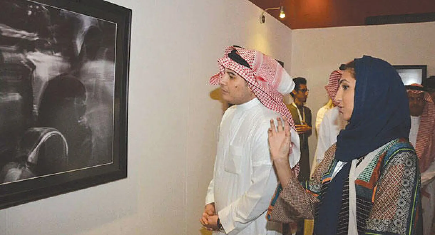 فادي جميل يطلع على إحدى الصور الفائزة وبجواره زين زيدان مديرة مبادرة الفن جميل