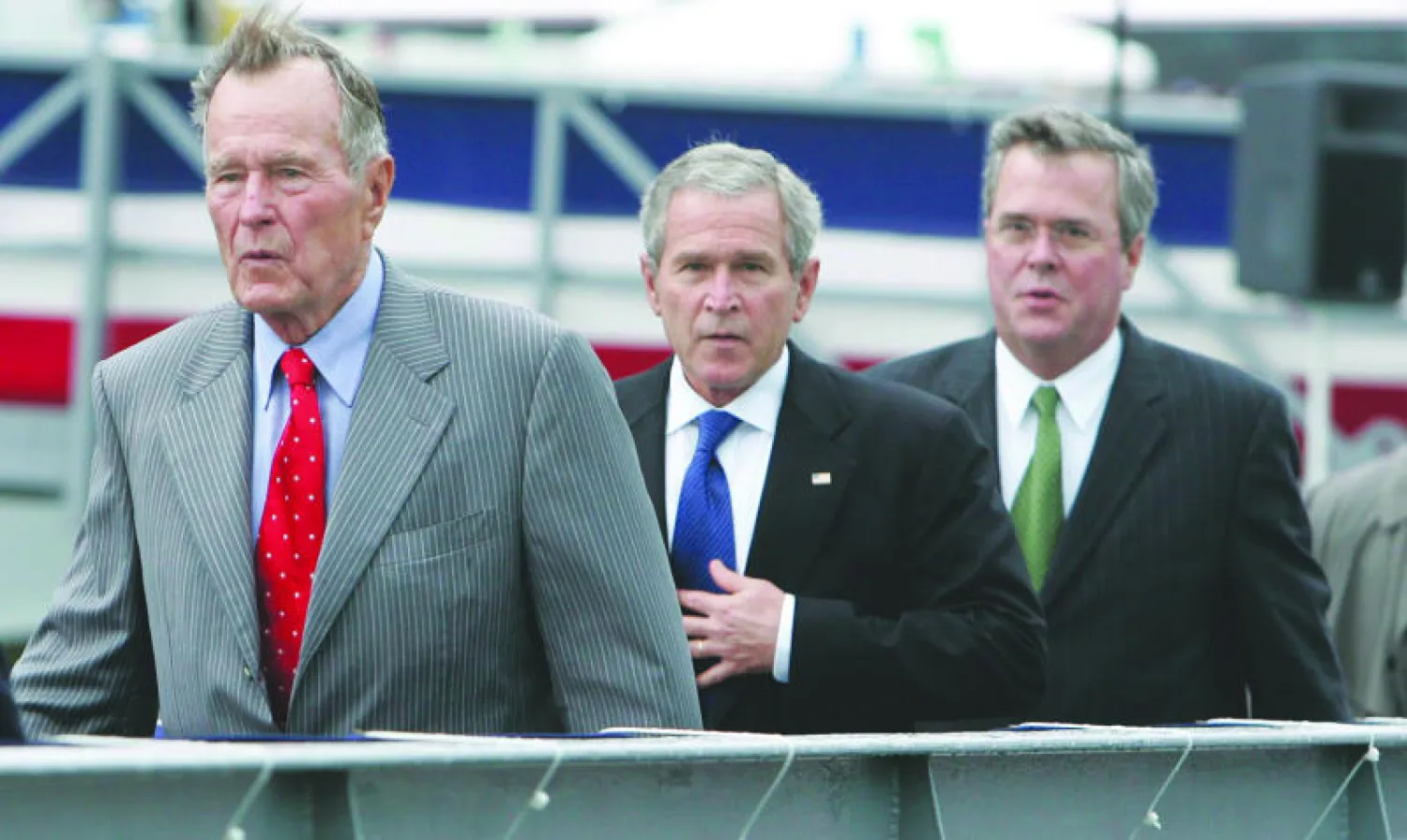 الرئيسان السابقان بوش الأب (يسار) وبوش الابن (وسط) والحاكم السابق لفلوريدا جيب بوش خلال حفل تدشين حاملة طائرات في فرجينيا عام 2006 (إ.ب.أ)