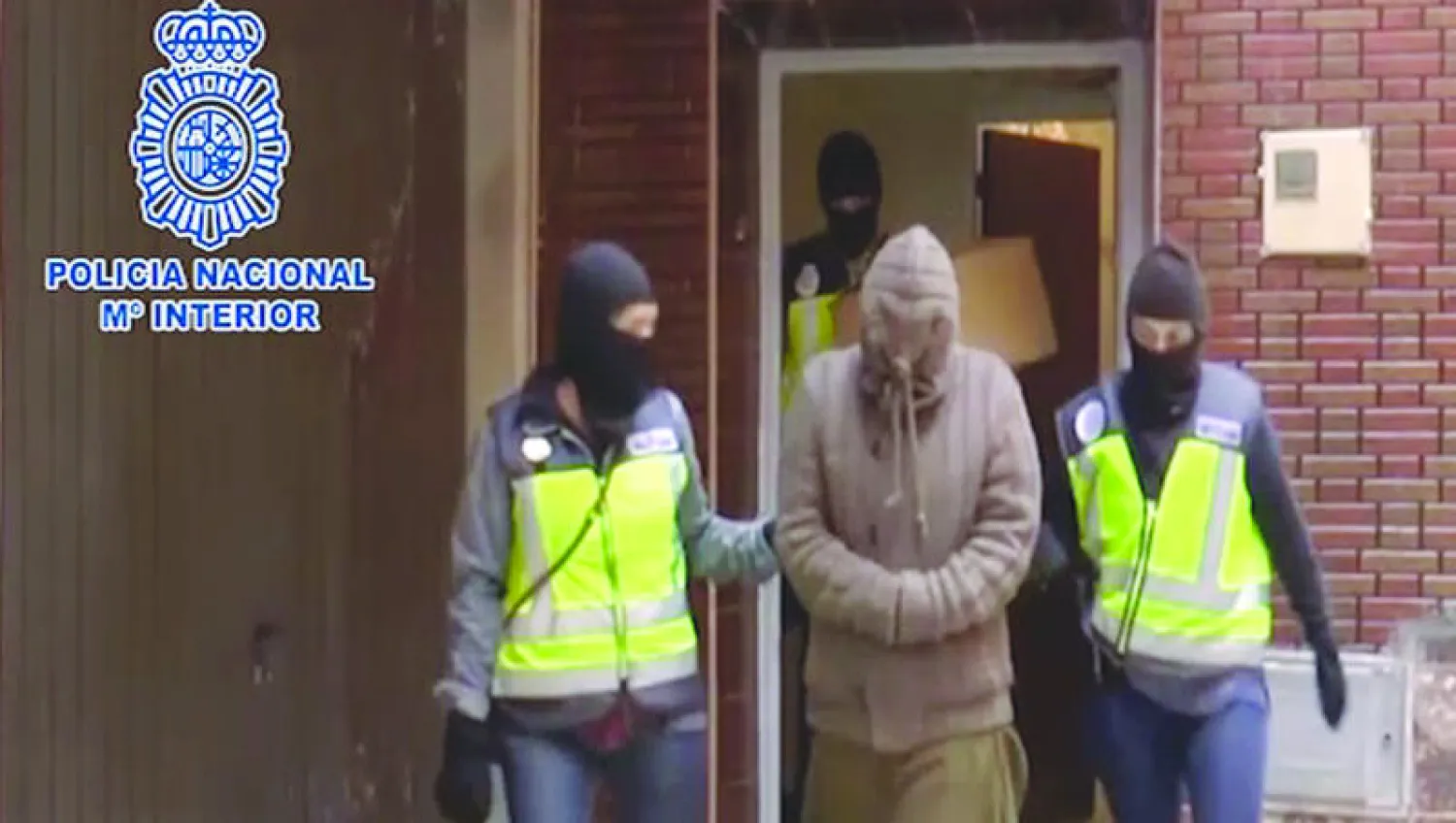 جنديان من الشرطة الإسبانية يقودان مشتبها به إثر نجاح المغرب وإسبانيا، بشكل متزامن أمس في  تفكيك خلية كانت تعمل في المدن الواقعة في الشمال المغربي ومناطق إسبانية، من أجل تجنيد نساء لصالح تنظيم داعش (أ.ف.ب)