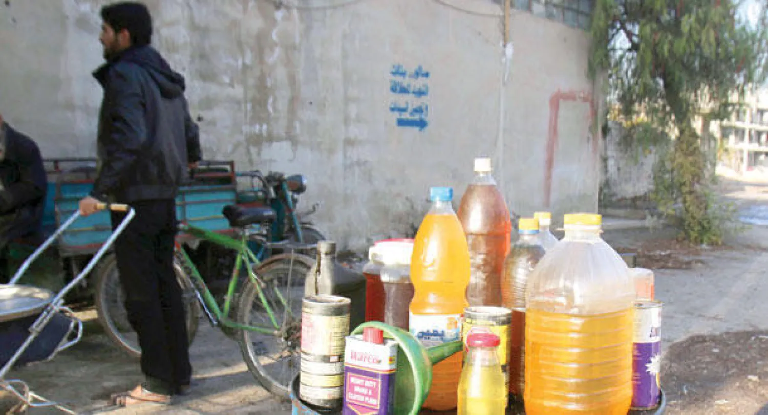 وقود للبيع في قناني البلاستيك التي يحرقها أهالي قرية عربين المحاصرة في ريف دمشق (رويترز)