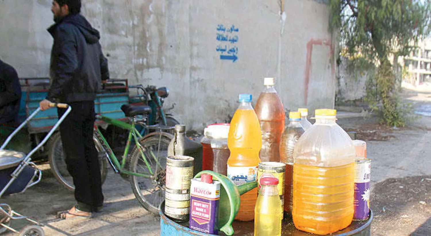 وقود للبيع في قناني البلاستيك التي يحرقها أهالي قرية عربين المحاصرة في ريف دمشق (رويترز)