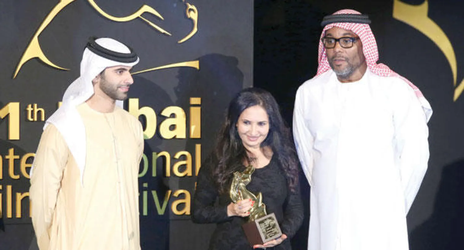 الشيخ منصور بن محمد بن راشد والمخرج الأميركي لي دانيالز (بالزي العربي) مع المخرجة اليمنية خديجة السلامي التي حصلت على جائزة أفضل فيلم روائي عن فيلمها «أنا نجوم بنت العاشرة ومطلّـقة» (إ.ب.أ)