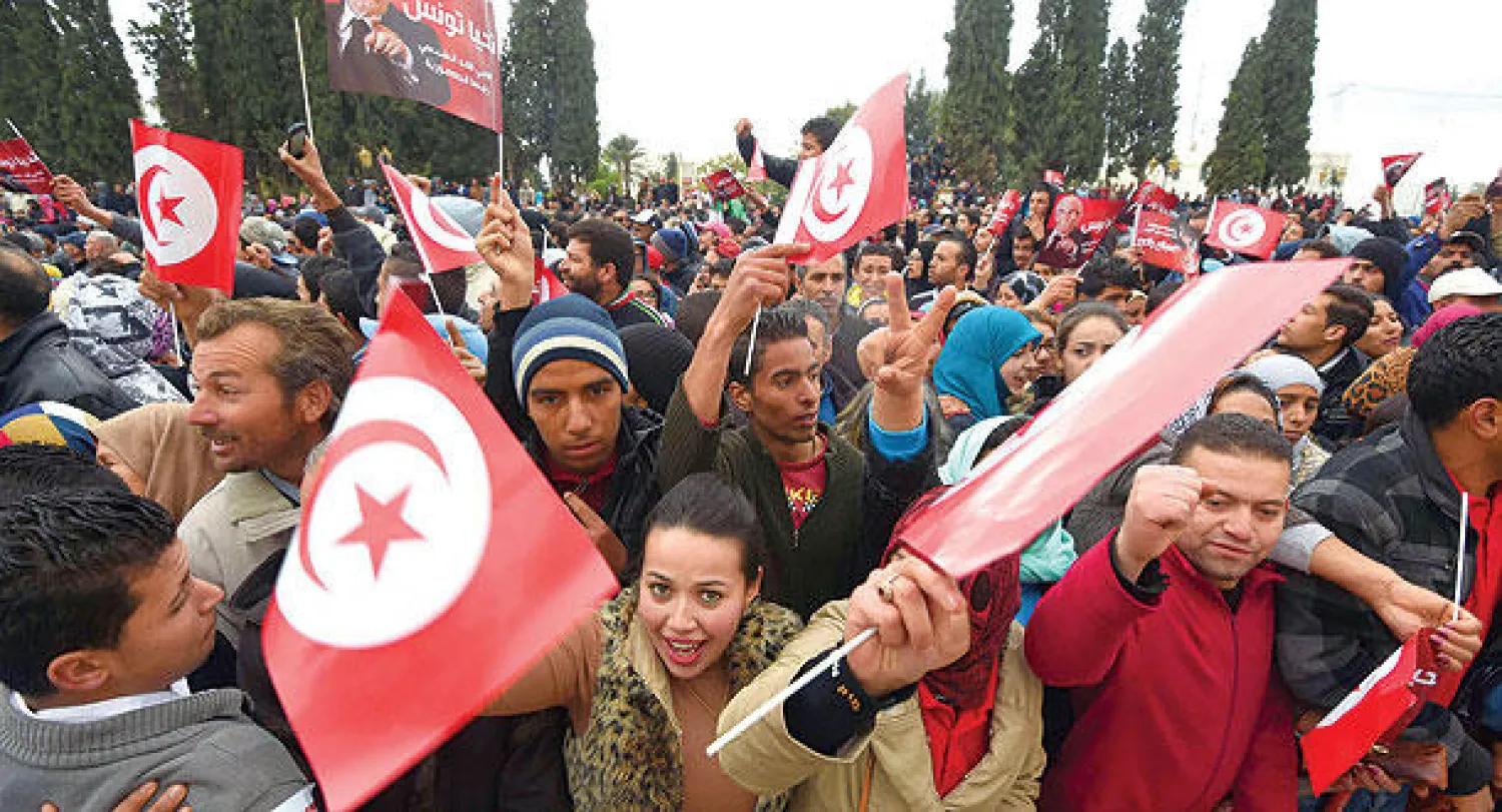 تونسيون مؤيدون للمرشح الرئاسي الباجي قائد السبسي يرفعون علم بلادهم في إحدى حملاته الانتخابية في تونس أمس (أ. ف. ب)
