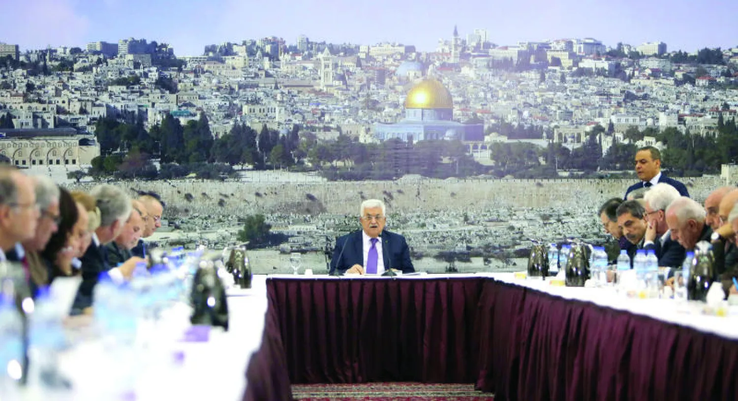 الرئيس الفلسطيني محمود عباس لدى لقائه عددا من القادة الفلسطينيين في رام الله أمس وخلفه لوحة ضخمة عن القدس يظهر فيها مسجد قبة الصخرة (أ.ف.ب)