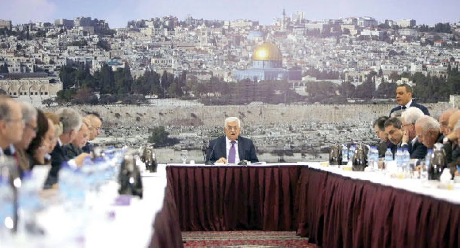 الرئيس الفلسطيني محمود عباس لدى لقائه عددا من القادة الفلسطينيين في رام الله أمس وخلفه لوحة ضخمة عن القدس يظهر فيها مسجد قبة الصخرة (أ.ف.ب)