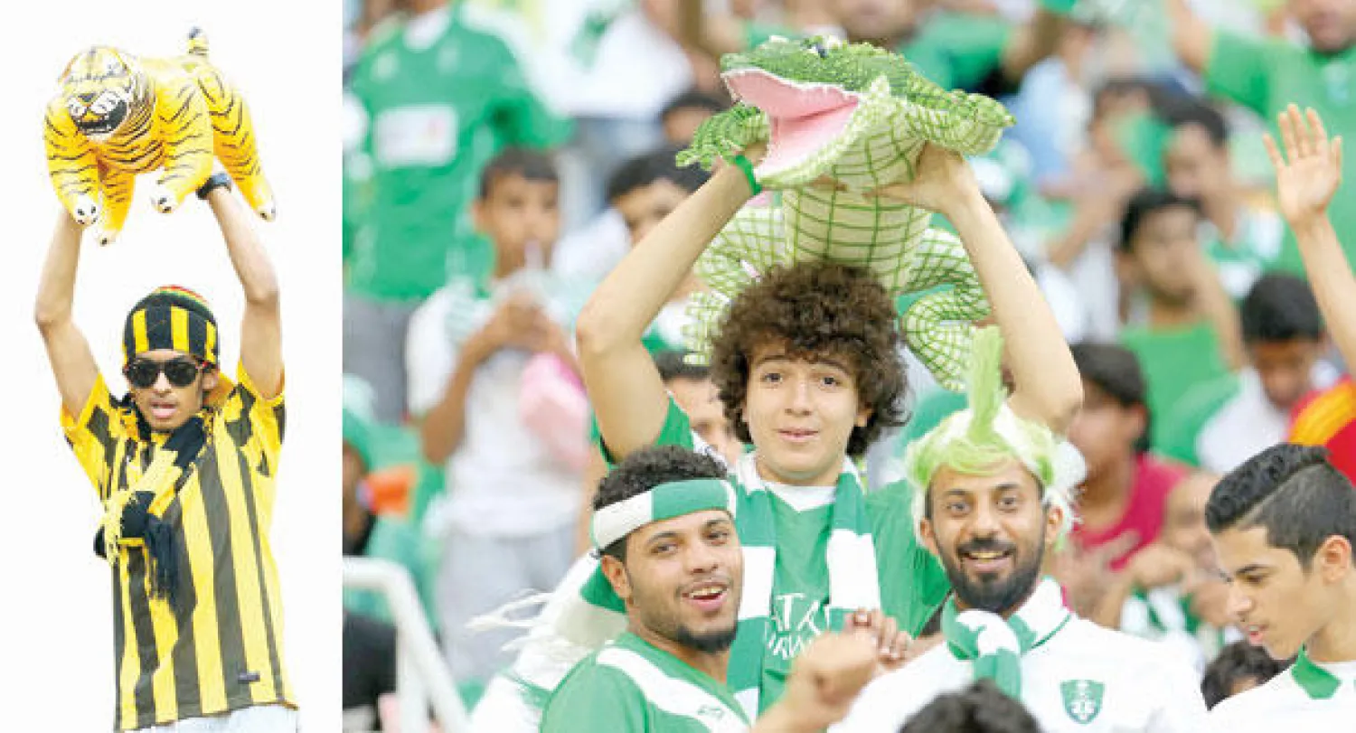 جانب من مدرجات الأهلي خلال الديربي أمس (تصوير: عبد الله بازهير)  -  مشجع اتحادي يحمل دمية النمر في المدرجات (تصوير: عبد الله بازهير)