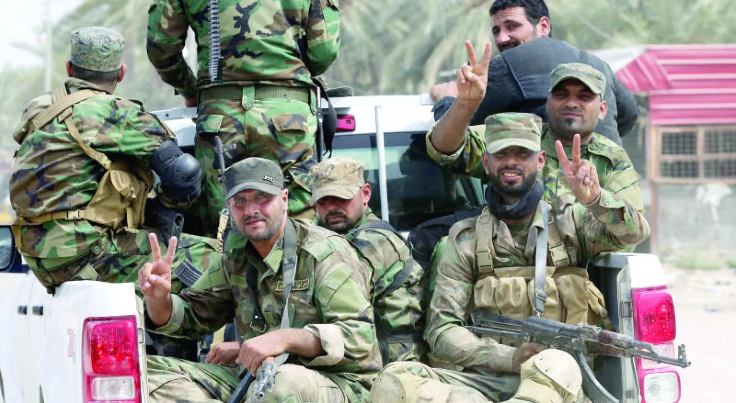 عناصر في «الحشد الشعبي» يتوجهون إلى الجبهة لقتال «داعش» في جرف الصخر إلى الجنوب من بغداد (أ.ب)