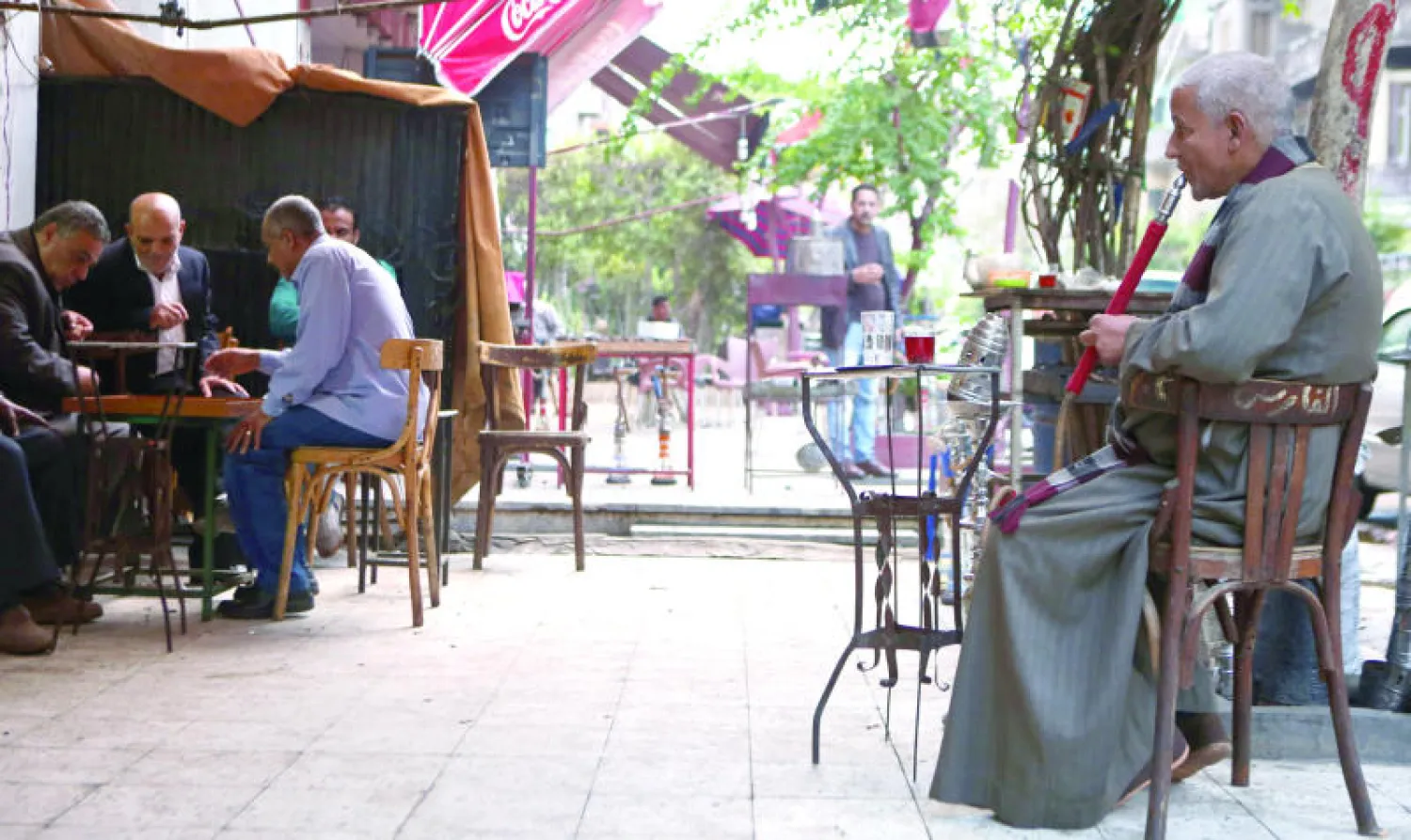 مواطن مصري يدخن النرجيلة بمقهى شمال القاهرة في وقت تشهد فيه مصر مزيدا من الاستقرار في ذكرى مرور 6 أشهر على حكم الرئيس عبد الفتاح السيسي (أ.ف.ب)