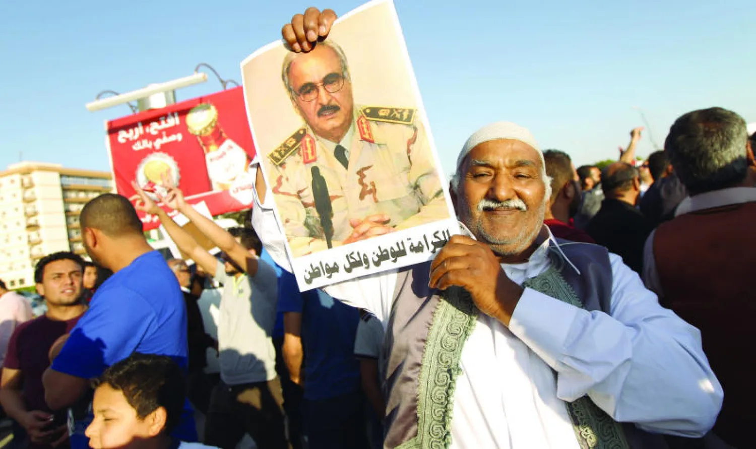 ليبي يحمل صورة للواء خليفة حفتر خلال مسيرة مؤيدة له في بنغازي أمس (غيتي)
