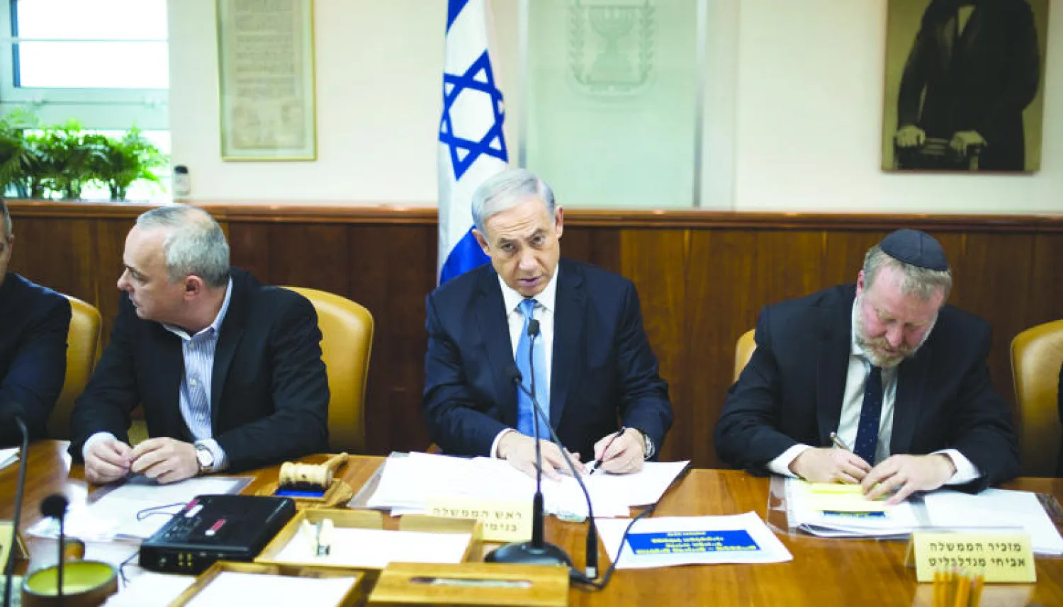 بنيامين نتنياهو (وسط) أثناء ترؤسه اجتماع الحكومة الأسبوعي (رويترز)
