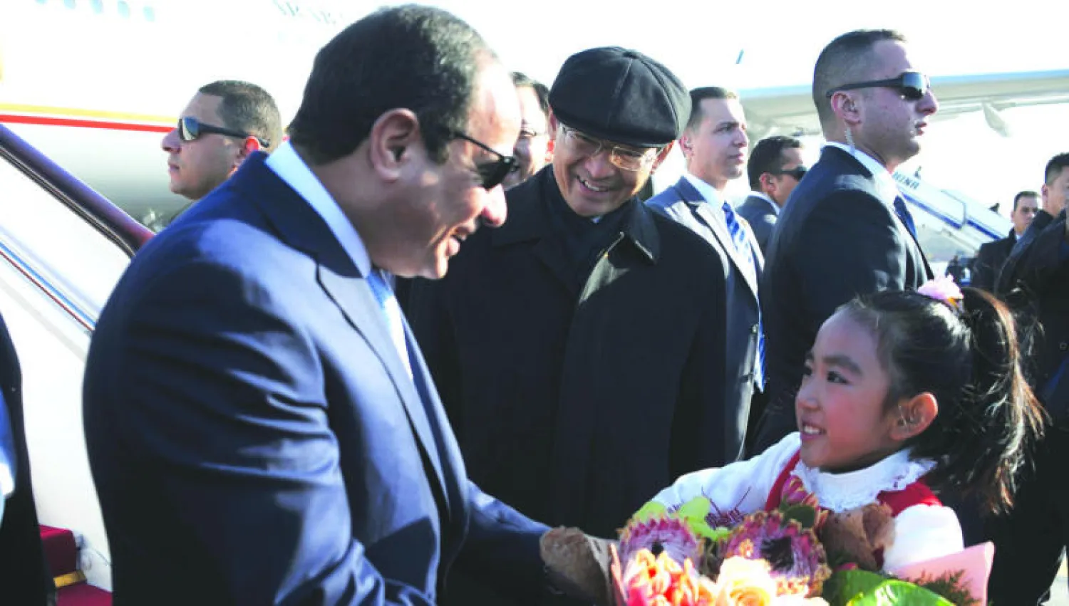 الرئيس المصري عبد الفتاح السيسي يتلقى باقة ورد من طفلة صينية لدى وصوله إلى مطار بكين أمس (الرئاسة المصرية)