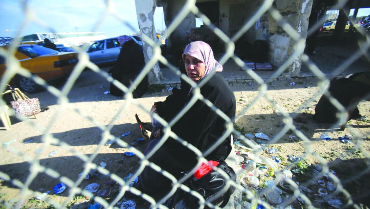 فلسطينية تنتظر بأمل العبور الى الجانب المصري في معبر رفح الحدودي مع قطاع غزة أمس ( رويترز)