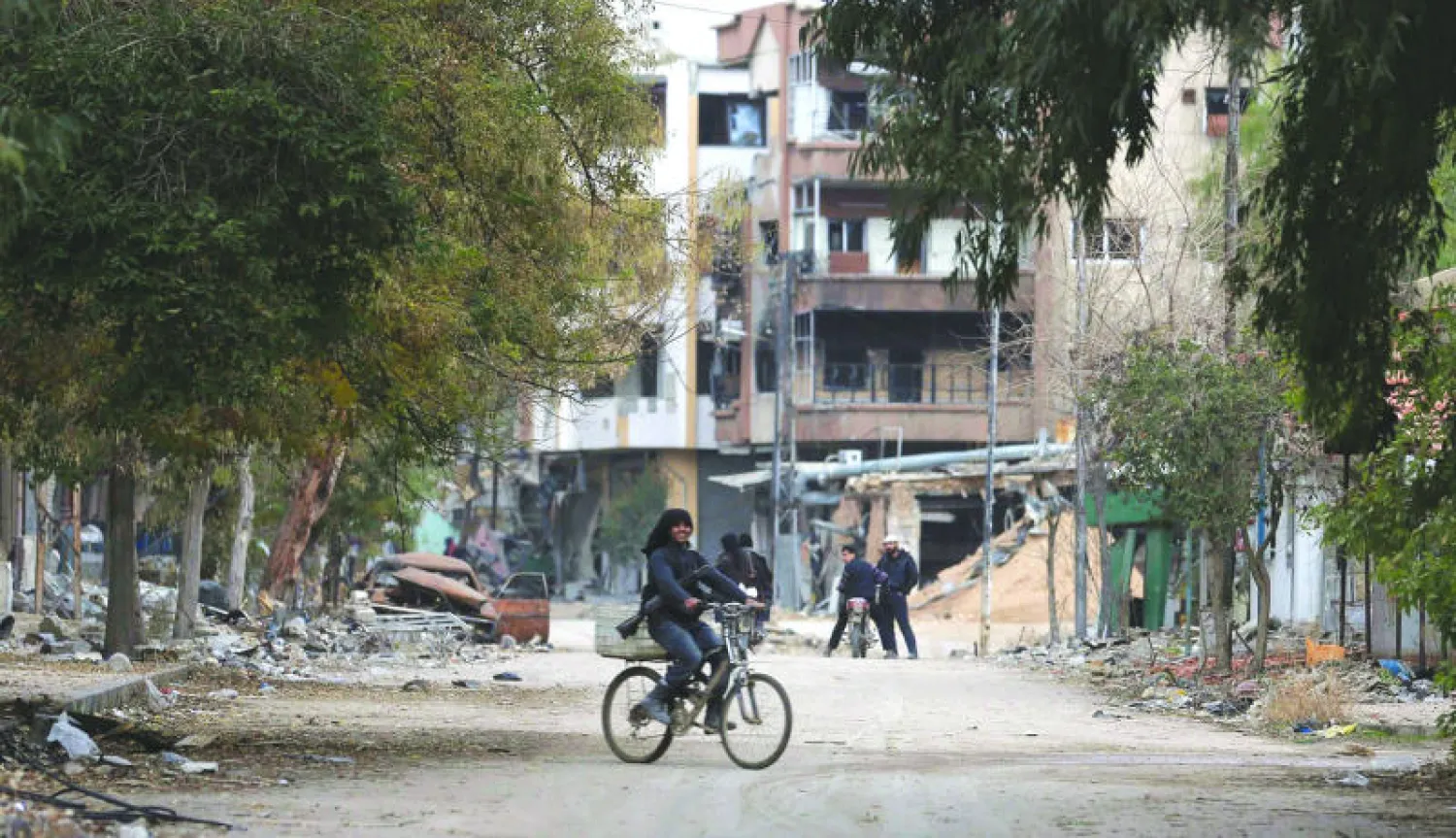 مسلح من المعارضة مع سلاحه يركب دراجة في منطقة جوبر بريف دمشق أمس (رويترز)