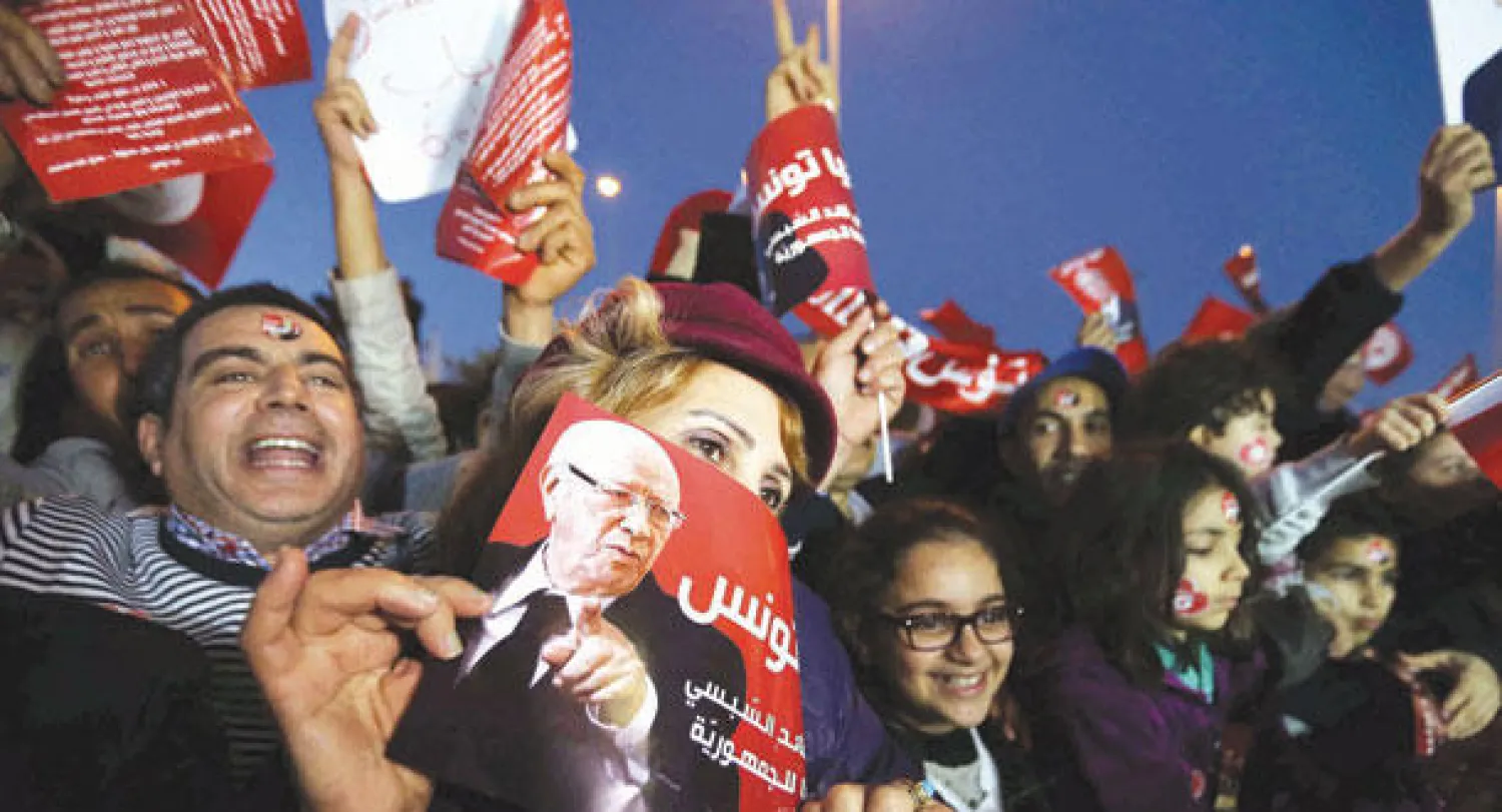 تونسيون مؤيدون للسبسي يحتفلون بعد إعلان فوزه بالرئاسة في العاصمة التونسية مساء أول من أمس (إ.ب.أ)