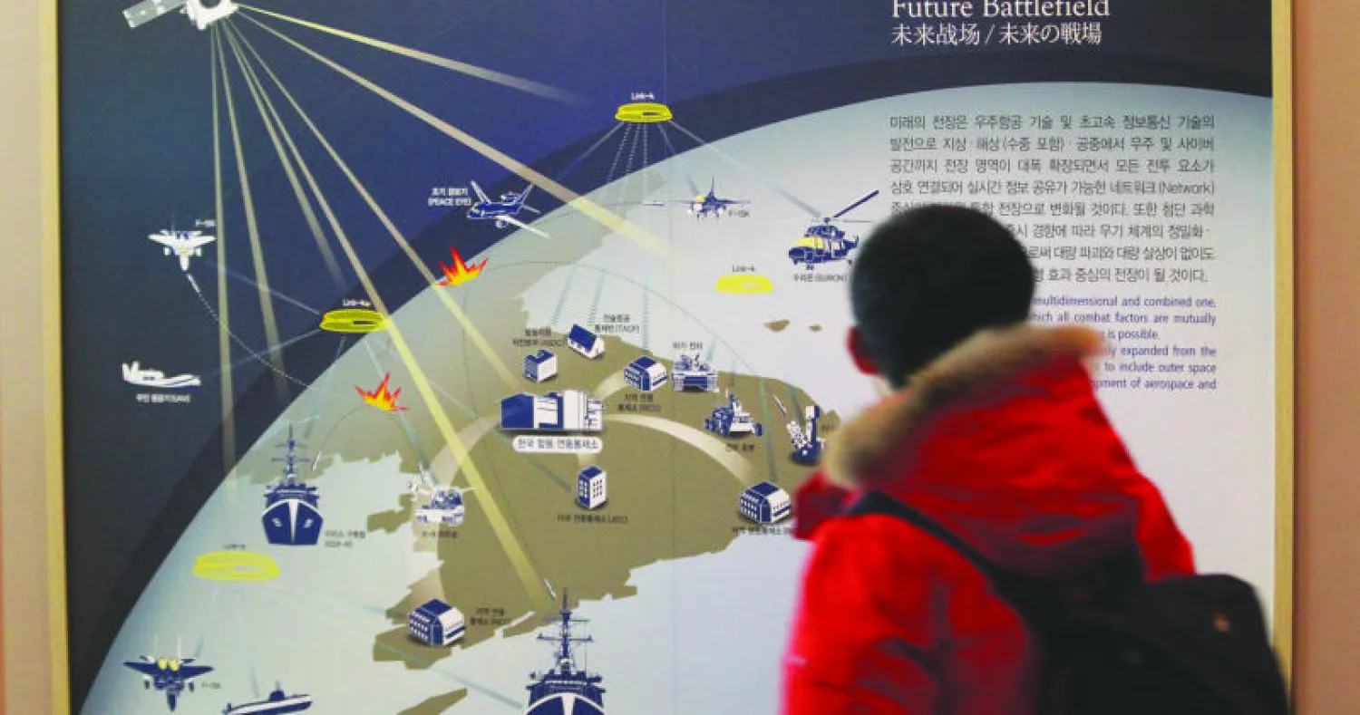 طالب كوري جنوبي يمر أمام صورة تشرح طبيعة الحرب الإلكترونية المستقبلية في شبه الجزيرة الكورية، في متحف الحرب بسيول أمس (أ.ب)