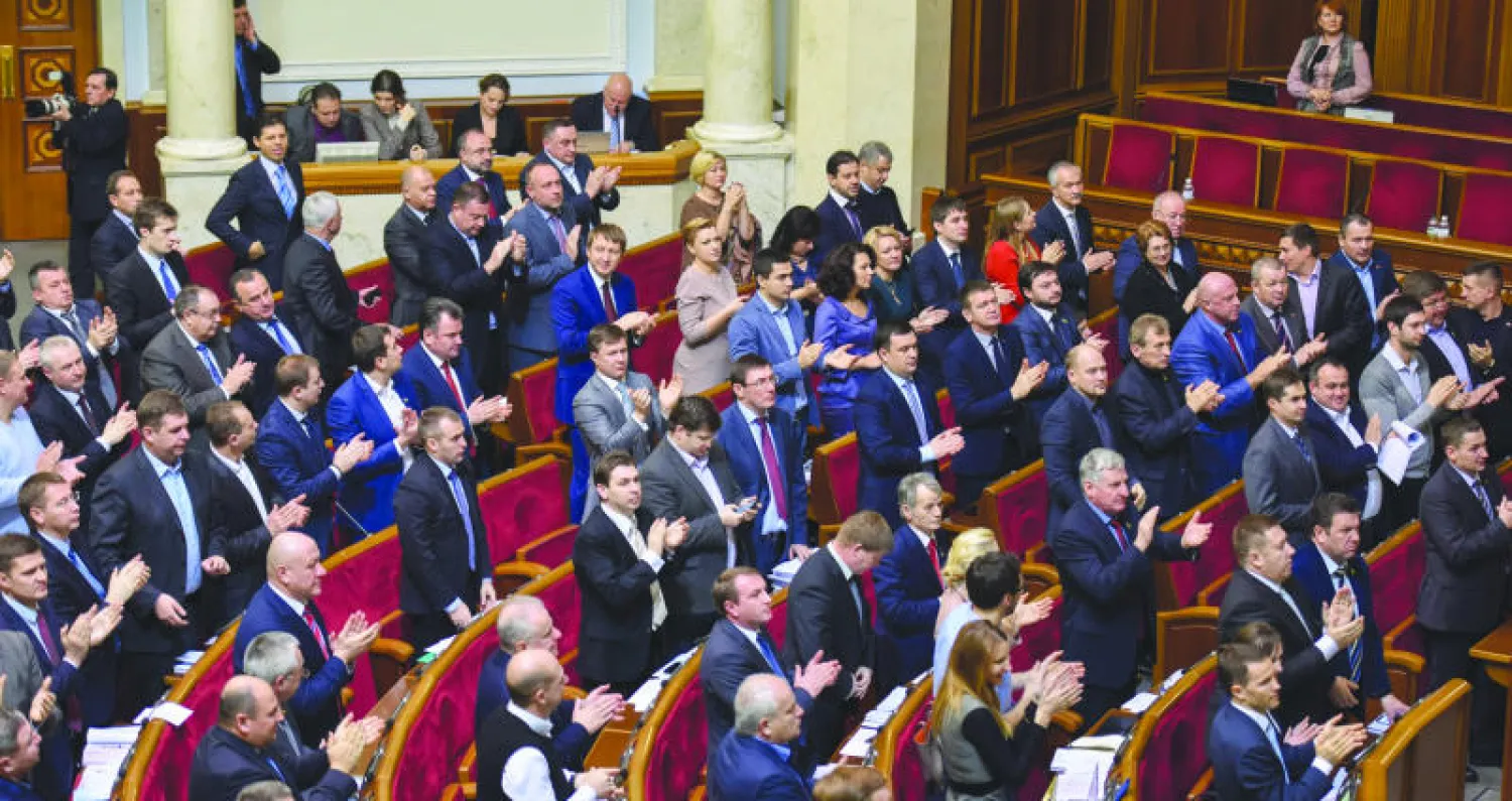النواب الأوكرانيون يصفقون بعد التصويت لصالح التخلي عن وضع الدولة غير المنحازة في البرلمان بكييف أمس (إ.ب.اأ)