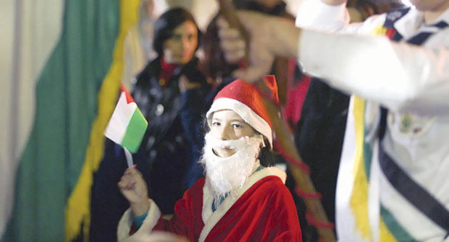 في كنيسة «القديس بريفيريوس» في الحي القديم بمدينة غزة.. كان عشرات المسيحيين يبحثون عن أسمائهم في قائمة تضم 521 شخصا فقط حصلوا على أذونات إسرائيلية للذهاب إلى بيت لحم (أ.ف.ب)