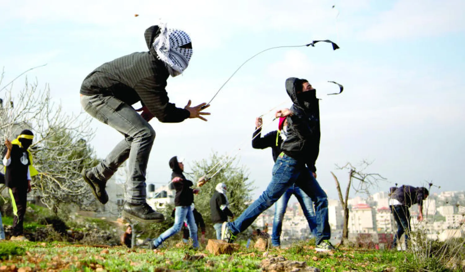 فلسطينيون يشتبكون بمقاليعهم مع القوات الاسرائيلية خارج السجن العسكري {عوفر} بالقرب من رام الله بالضفة الغربية أمس (أ.ف.ب)