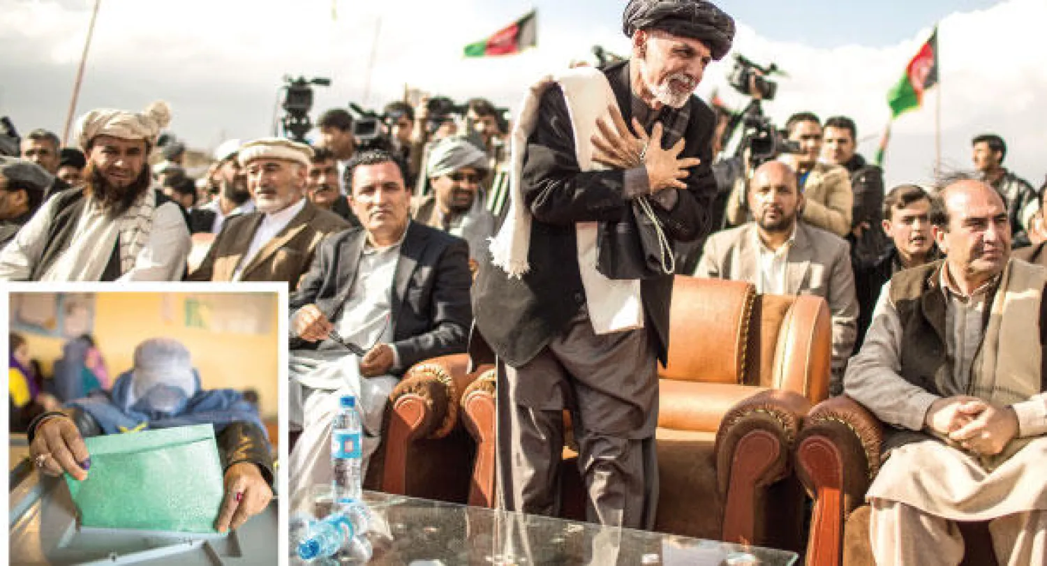 أشرف غني خلال حملته الانتخابية الرئاسية في 22 مارس الماضي (نيويورك تايمز) و أفغانية تدلي بصوتها في الانتخابات الرئاسية في مزار شريف يوم 5 ابريل (نيسان) الماضي (رويترز)