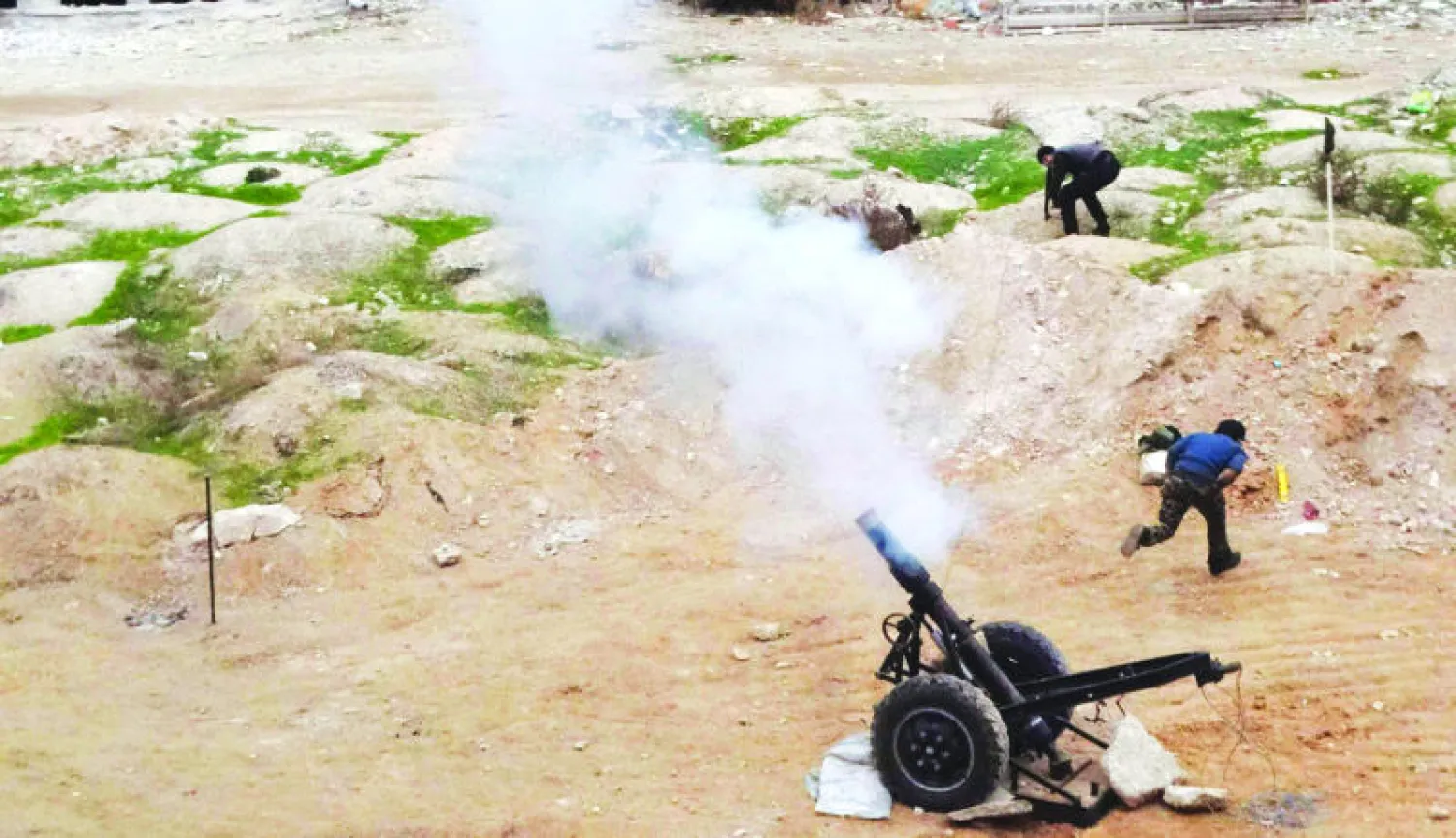 مقاتلو الجيش السوري الحر يوجهون نيرانهم باتجاه قوات النظام في عين ترما بضواحي دمشق أمس (رويترز)