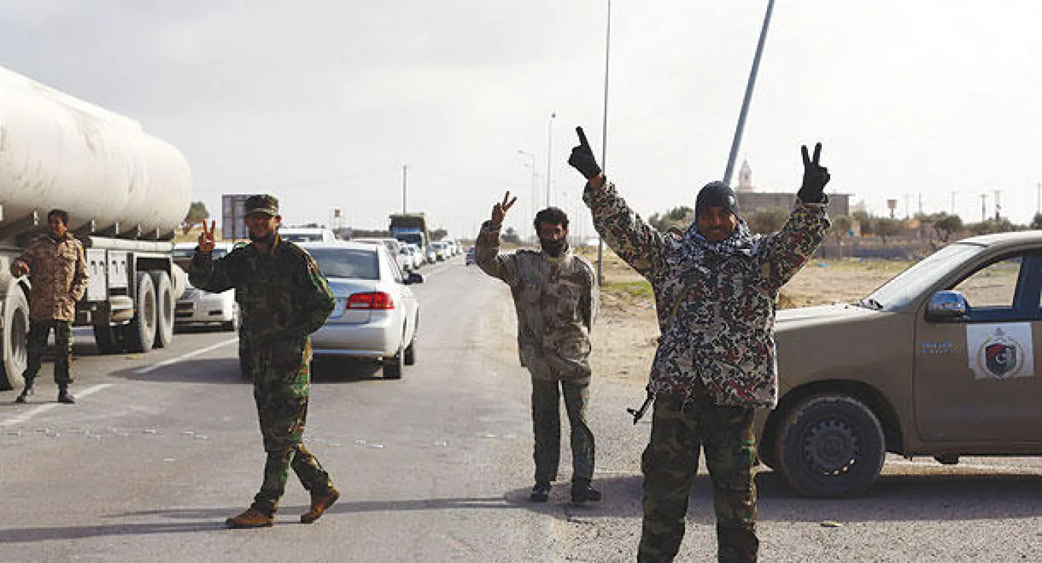 عناصر من ميليشيا {فجر ليبيا} يرفعون شارة النصر بعد سيطرتهم على محطة نفط وغاز مليطة في منطقة زوارة أمس (أ.ف.ب)