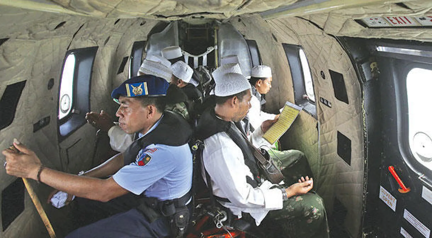 أئمة مسلمون يدعون لضحايا طائرة «إير آسيا» على متن طائرة عسكرية إندونيسية أمس (أ.ف.ب)