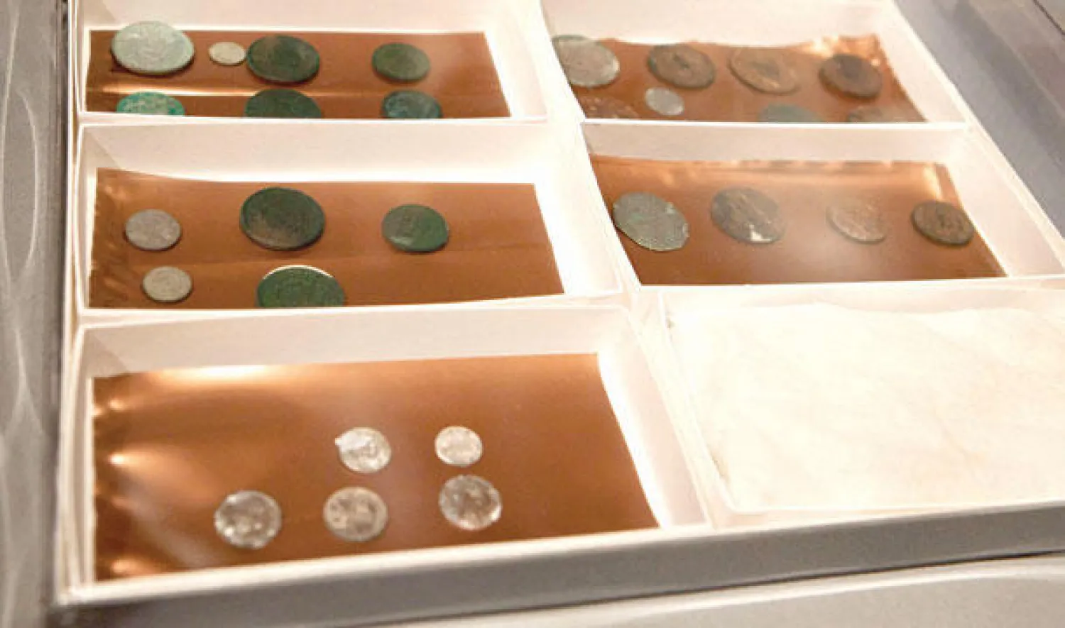 عملات معدنية ووثائق تركها صامويل آدمز وبول ريفير (أ.ف.ب)