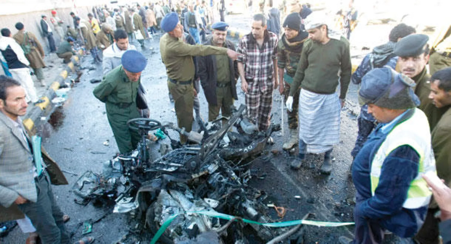 محققون ورجال أمن يعاينون الموقع الذي تعرض للهجوم بسيارة مفخخة في صنعاء أمس (أ.ب)