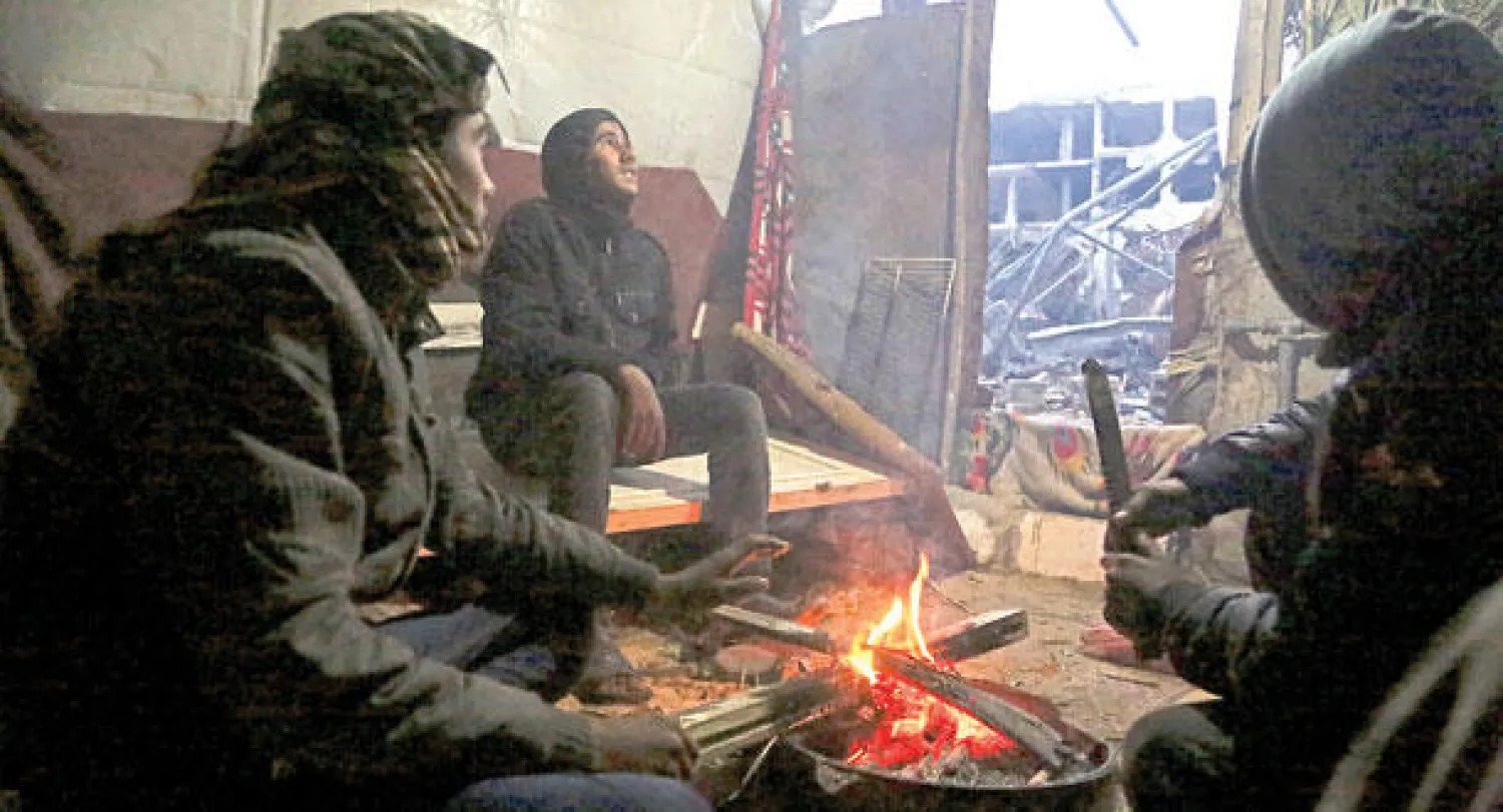 عائلة فلسطينية توقد النيران في منزلها بغزة طلبا للدفء بعد العاصفة الثلجية التي ضربت الأراضي الفلسطينية أمس (أ.ب)