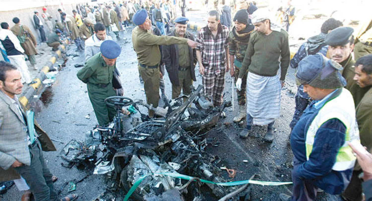 محققون ورجال أمن يعاينون الموقع الذي تعرض للهجوم بسيارة مفخخة في صنعاء أمس (أ.ب)