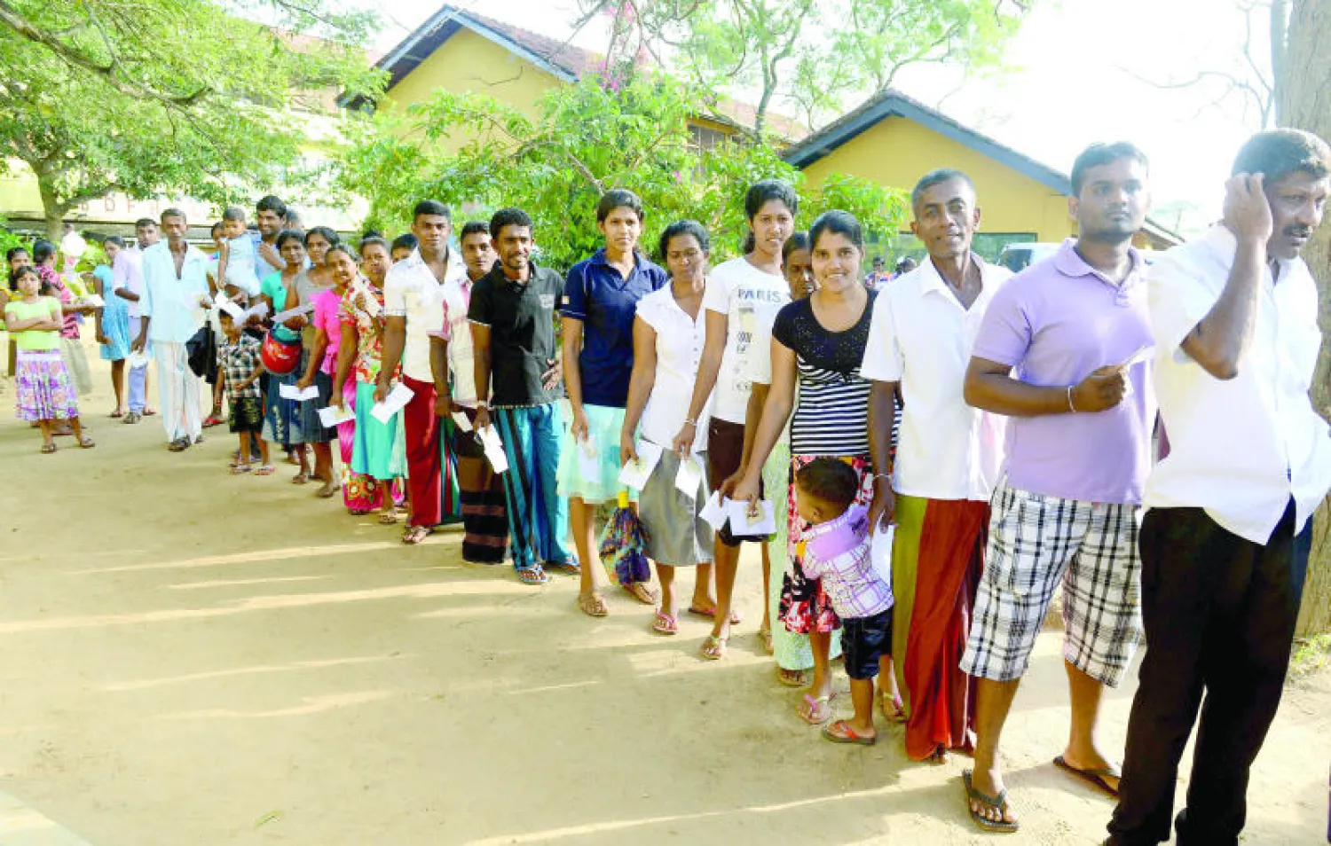 سريلانكيون ينتظرون في طابور من أجل الإدلاء بأصواتهم في مركز اقتراع بمدينة تانغالا البعيدة 195 كلم عن العاصمة كولومبو أمس (أ.ف.ب)